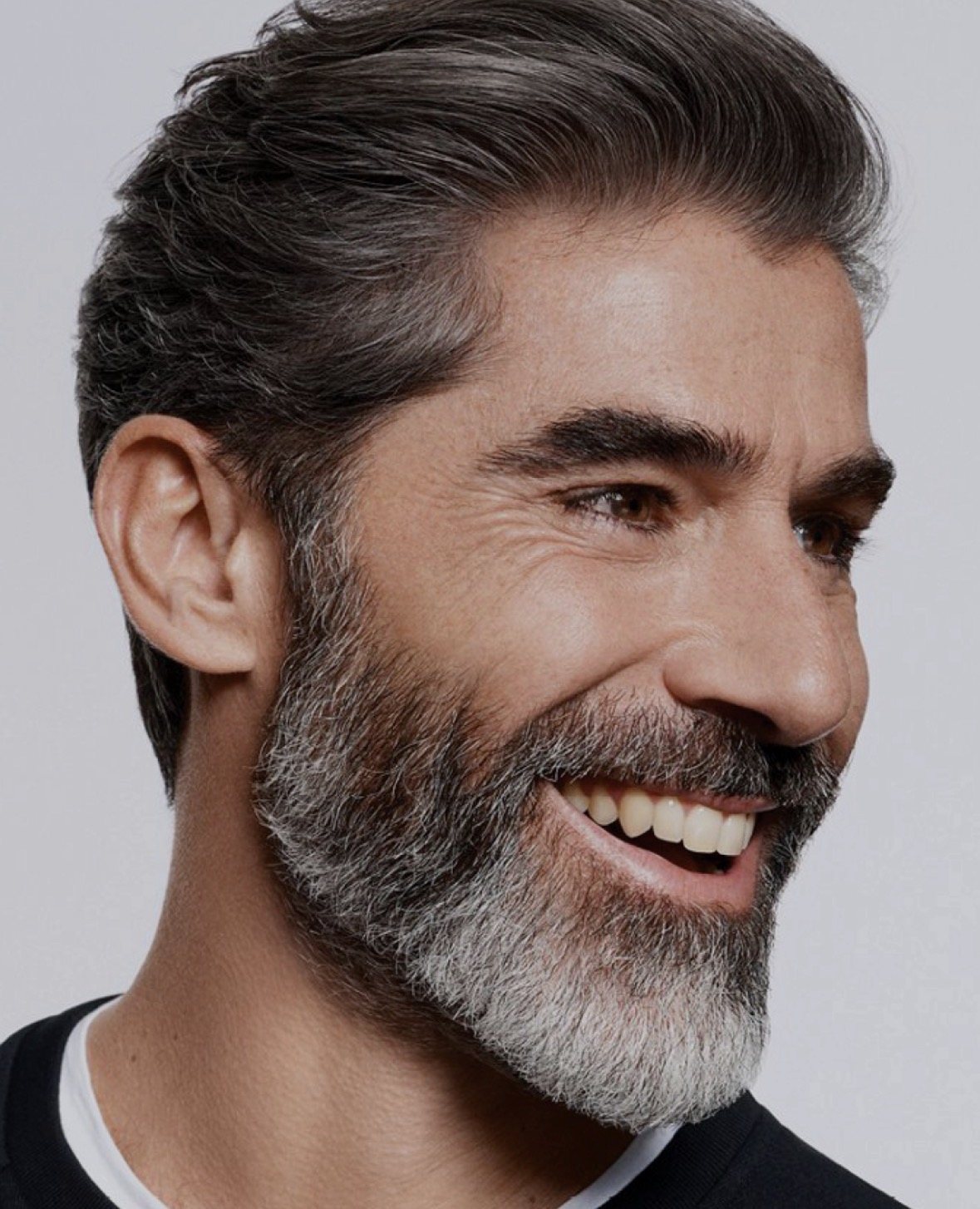 Man with swept-back silver-streaked hair and a sculpted salt-and-pepper beard